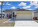 Charming single-story home featuring a two-car garage and colorful landscaping at 2049 Shannon Lakes Blvd, Kissimmee, FL 34743