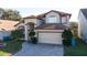 Attractive two-story home featuring a two-car garage, a paved driveway, and lush lawn at 2110 Korat Ln, Maitland, FL 32751