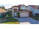 Two-story home featuring an attached two-car garage, a paved driveway, and attractive landscaping at 2110 Korat Ln, Maitland, FL 32751