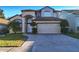 Beautiful two-story home with an attached two-car garage, a paved driveway, and meticulously manicured lawn at 2110 Korat Ln, Maitland, FL 32751