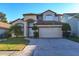 Charming two-story home with an attached two-car garage, paved driveway and green grass at 2110 Korat Ln, Maitland, FL 32751