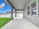 Covered back patio area offering a comfortable outdoor space with views of the fenced backyard and green lawn at 2279 Raven Ridge Road, Minneola, FL 34715