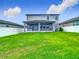 Lush backyard featuring a covered patio and vibrant green lawn, enclosed by a white fence for privacy and security at 2279 Raven Ridge Road, Minneola, FL 34715