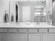 Well-lit bathroom featuring double sinks, a spacious vanity, and a large mirror at 2279 Raven Ridge Road, Minneola, FL 34715