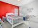 Lively bedroom with red accent wall and fire truck themed decor at 2279 Raven Ridge Road, Minneola, FL 34715