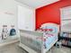 Bright bedroom featuring a crib with fire truck bedding and playful decor at 2279 Raven Ridge Road, Minneola, FL 34715