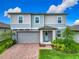 Charming two-story home featuring a stylish gray exterior, covered entryway, and attached garage at 2279 Raven Ridge Road, Minneola, FL 34715