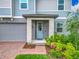 Inviting front entrance with a light blue door, stone accents, and manicured landscaping, creating a welcoming appeal at 2279 Raven Ridge Road, Minneola, FL 34715