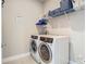 Well-lit laundry room featuring a modern washer and dryer, complemented by practical shelving for storage at 2279 Raven Ridge Road, Minneola, FL 34715