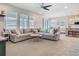 Bright and airy living room showcasing a plush sofa, a ceiling fan, and a view into the kitchen at 2279 Raven Ridge Road, Minneola, FL 34715
