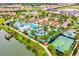 An aerial view of the clubhouse, lazy river, and pool, with a lake and recreational area in the background at 2408 Dubai St, Kissimmee, FL 34747