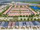 Aerial view of the community showcasing townhomes, single Gathering homes, landscaped streets, and a central lake at 2408 Dubai St, Kissimmee, FL 34747