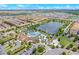 Beautiful aerial view of community with lake, pool, clubhouse, and manicured landscaping at 2408 Dubai St, Kissimmee, FL 34747