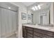Bathroom featuring double sinks with granite countertop, dark cabinets and separate toilet room at 2408 Dubai St, Kissimmee, FL 34747
