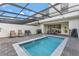 Relaxing screened-in pool area with comfortable lounge chairs and outdoor dining area at 2408 Dubai St, Kissimmee, FL 34747
