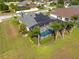 Back aerial view of home showing screened in pool, solar panels, lush landscaping, and fence at 3037 Diamond Ln, St Cloud, FL 34772