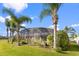 Backyard with screened-in pool and beautifully landscaped area featuring several palm trees at 3037 Diamond Ln, St Cloud, FL 34772
