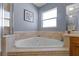 Bathroom with soaking tub with beige tile and a window at 3037 Diamond Ln, St Cloud, FL 34772