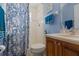 Bathroom with a wooden vanity, enclosed shower, and blue accents at 3037 Diamond Ln, St Cloud, FL 34772