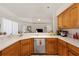 Bright kitchen has wood cabinets, white countertops, stainless steel appliances, and a view to the living room at 3037 Diamond Ln, St Cloud, FL 34772