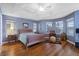 Bright main bedroom with wood floors, tray ceilings, a ceiling fan, and views to the water at 3037 Diamond Ln, St Cloud, FL 34772