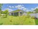 Backyard view showcasing a screened-in patio and a garden area with young trees and plants at 3191 Marshfield Preserve Way, Kissimmee, FL 34746