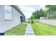 Backyard view featuring a concrete block path, lush green grass, and well-maintained landscaping at 3191 Marshfield Preserve Way, Kissimmee, FL 34746