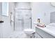 Bathroom with a white toilet, shower, grey countertop, and marble flooring at 3191 Marshfield Preserve Way, Kissimmee, FL 34746