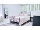 Bedroom with light pink comforter, decorative hanging vines, and a mirror at 3191 Marshfield Preserve Way, Kissimmee, FL 34746