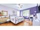 Bedroom features a large bed frame, wood floor, and a stylish purple color scheme at 3191 Marshfield Preserve Way, Kissimmee, FL 34746