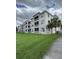 Exterior shot of a three-story condominium building with green lawn and screened patios at 3321 Whitestone Cir # 204, Kissimmee, FL 34741