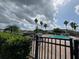 Community pool area with lounge chairs, lush landscaping, a spa and palm trees under a cloudy sky at 3321 Whitestone Cir # 204, Kissimmee, FL 34741