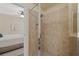 Bathroom features tiled shower with glass door and neutral walls, offering a glimpse into the main bedroom at 3535 Clay Brick Rd, Harmony, FL 34773