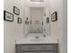 Neat half-bath featuring gray vanity with framed mirror and decorative wall accents at 3535 Clay Brick Rd, Harmony, FL 34773