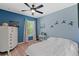 Comfortable bedroom with blue accent wall, ceiling fan, and ample natural light, creating a cozy and inviting space at 3535 Clay Brick Rd, Harmony, FL 34773