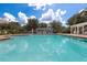 Spacious community pool with clear blue water, surrounded by lounge chairs and green landscaping in a relaxed setting at 3535 Clay Brick Rd, Harmony, FL 34773