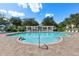 Community pool with a clear blue water, surrounded by lush landscaping and plenty of seating for residents at 3535 Clay Brick Rd, Harmony, FL 34773