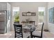 Bright dining area featuring a modern table set with natural lighting from large windows with green outdoor view at 3535 Clay Brick Rd, Harmony, FL 34773
