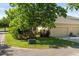 Home exterior featuring a well-kept lawn, mature trees, and beautiful landscaping, enhancing curb appeal at 3535 Clay Brick Rd, Harmony, FL 34773