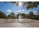 Community fountain featuring a circular design, surrounded by benches and lush landscaping on a sunny day at 3535 Clay Brick Rd, Harmony, FL 34773
