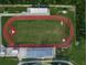 Aerial view of a running track with red lanes and a green field, showcasing athletic facilities at a school at 3535 Clay Brick Rd, Harmony, FL 34773