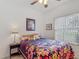Bright bedroom with a floral bedspread, ceiling fan, and a side table at 4117 Navigator Way, Kissimmee, FL 34746