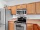 Well-equipped kitchen features stainless steel appliances and natural wood cabinetry at 4117 Navigator Way, Kissimmee, FL 34746
