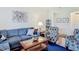 Cozy living room featuring plush blue seating, a glass-topped coffee table, and stylish decor at 4117 Navigator Way, Kissimmee, FL 34746