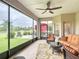Enclosed patio with view of green lawn, lake, lounge chairs, and large screened windows at 4117 Navigator Way, Kissimmee, FL 34746