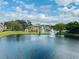 Serene aerial view of complex's pond with fountains, lush greenery, and building exteriors set under a partly cloudy sky at 4301 Lizshire Ln # 308, Orlando, FL 32822