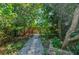Backyard featuring a stone pathway surrounded by lush greenery, creating a serene and private outdoor retreat at 4611 Eaglet Ln, Kissimmee, FL 34746