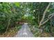 Lush backyard garden path featuring stone pavers and mature trees, creating a tranquil outdoor experience at 4611 Eaglet Ln, Kissimmee, FL 34746