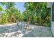 Spacious backyard featuring mature trees and a concrete patio with table and chairs at 4611 Eaglet Ln, Kissimmee, FL 34746