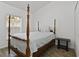 Comfortable bedroom with a four-poster bed, wood-look floors, and a bright window at 4611 Eaglet Ln, Kissimmee, FL 34746